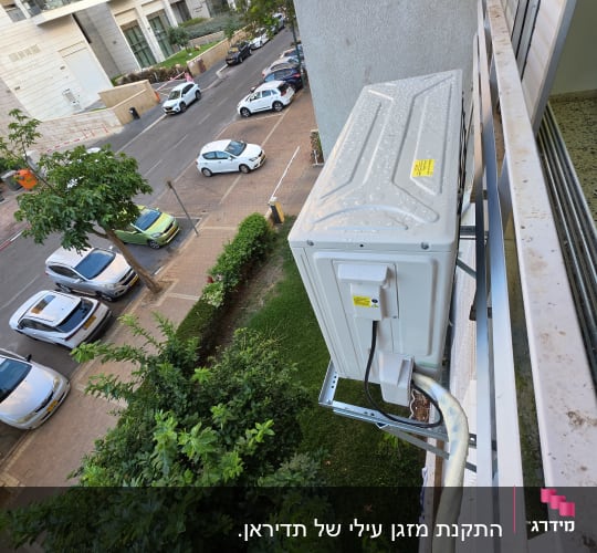 התקנת יחידה חיצונית של מזגן על תושבת מחוץ לחלון בבניין מגורים